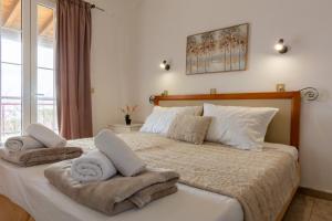 a bedroom with a large bed with towels on it at Sailor's Apartments Kavos in Kavos