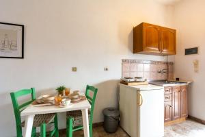 a kitchen with a small table and a small refrigerator at Sailor's Apartments Kavos in Kavos