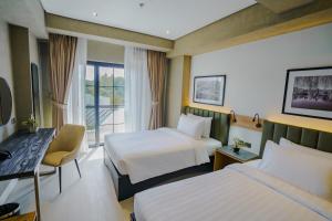 ein Hotelzimmer mit zwei Betten und einem Fenster in der Unterkunft Venus Parkview Hotel in Baguio City + 60 Fotos