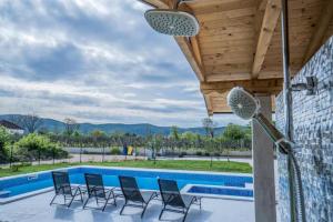 a patio with chairs and a swimming pool at Villa Modriola with heated pool in Donji Proložac - Imotski in Donji Proložac