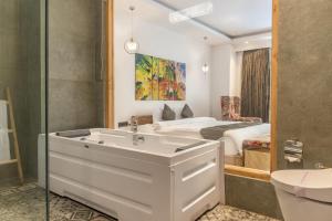a bathroom with a tub and a bedroom with a bed at Echor Palm Bliss Resort & Spa, Kasol in Kasol