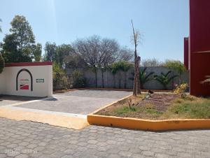a building with a tree in the middle of a driveway at Campo Real Actopan in Cedro