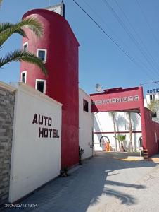a red and white building with a palm tree next to it at Campo Real Actopan in Cedro