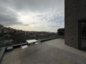 a balcony with a table and chairs on a building at Maison by Grey Pearls Suites in Mīnāʼ al ‘Atīqah