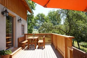 a wooden deck with a table and chairs on it at Biohof Prannleithen - Knusperhaus in Yspertal