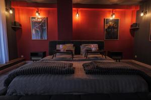 a bedroom with a large bed with red walls at CinémaRoom Béziers in Béziers