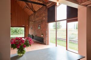 a room with a table with a vase of flowers at B&B De Deugdzonde in Sint-Denijs