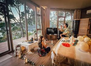 a man and a woman sitting at tables in a room at The Cocoon - Glamping at Karuna El Nido in El Nido