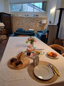 a table with two plates of food on it at L'estrade des Alpes 45m2 petit-déjeuner inclus in Saint-Alban-de-Roche