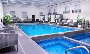 a pool in a hotel with chairs at The Brock Niagara Falls Fallsview, Tapestry by Hilton in Niagara Falls