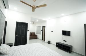 a bedroom with a bed and a ceiling fan at Aacasa Living Resorts in Shamshabad