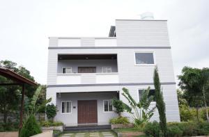 a white house with a red door and some plants at Aacasa Living Resorts in Shamshabad