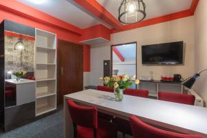 a dining room with red walls and a white table and red chairs at Hotel Przystanek Torun in Toruń