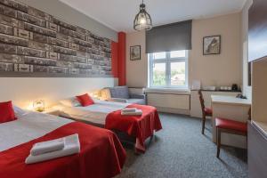 a hotel room with two beds and a desk at Hotel Przystanek Torun in Toruń +123 photos