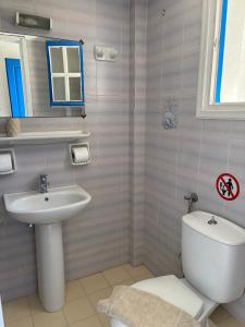 a bathroom with a white toilet and a sink at Athina Studios in Vathí +48 photos