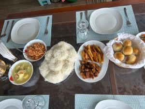 a table with plates and bowls of food on it at Sinharaja Geo Dome in Nelluwa