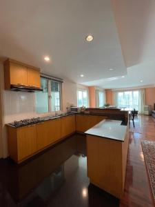 a large kitchen with wooden cabinets and a kitchen island at 6A SANTUBONG SUITES by MF in Kuching
