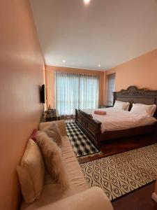 a large bedroom with a bed and a couch at 6A SANTUBONG SUITES by MF in Kuching