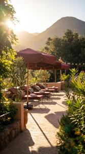 a group of chairs and umbrellas on a patio at villa lalla Ourika & heated pool in Aghbalou