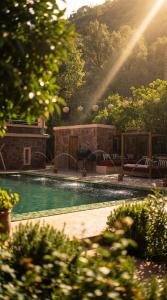 a swimming pool in a garden with a rainbow in the background at villa lalla Ourika & heated pool in Aghbalou