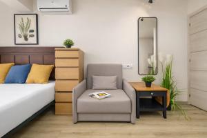 a bedroom with a bed and a chair and a mirror at Beachfront Design LUX Studio Apartment in Estepona