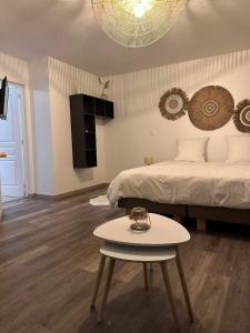 a bedroom with a bed and a table in front of it at Chambre d'hôte La Kazanou in Saint-Joseph +22 photos