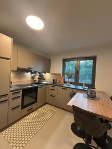 a kitchen with a wooden table and a table and a window at Apartment Wörtherseeliebe in Pörtschach am Wörthersee