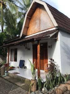 a small white house with a thatched roof at beaches Lyfe Rooms in Kuta Lombok +12 photos