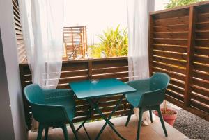 a small table and two chairs on a balcony at Chambre d'hôte La Kazanou in Saint-Joseph