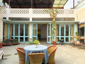 a patio with a table and chairs and a building at Jaipur Jantar Hostel in Jaipur