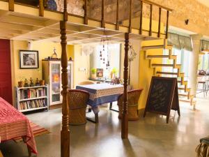 a room with a bed with a table and chairs at Jaipur Jantar Hostel in Jaipur