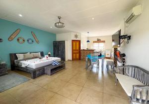 a bedroom with a bed and a dining room at Coral Apartments in La Digue