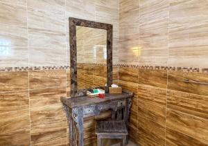 a bathroom with a wooden wall with a mirror at Coral Apartments in La Digue +6 photos