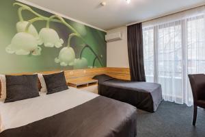 a hotel room with two beds and a window at Семеен Хотел Опера in Burgas
