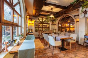 a restaurant with tables and chairs and windows at Семеен Хотел Опера in Burgas