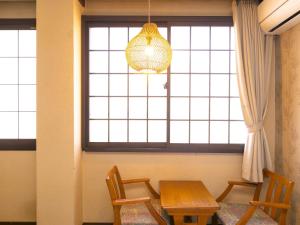 a dining room with a table and chairs and a window at Hotaru no Yado Sendou in Yufu
