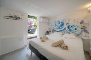 a bedroom with a bed with blue roses on the wall at FRGK "4 Suites Privées Exclusives" in Cannes