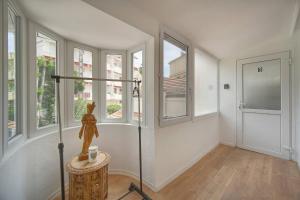 a room with windows and a statue on a table at FRGK "4 Suites Privées Exclusives" in Cannes
