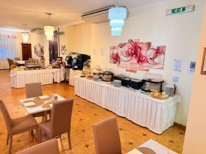 a restaurant with white tables and chairs and a buffet at Hotel Principe in Sanremo