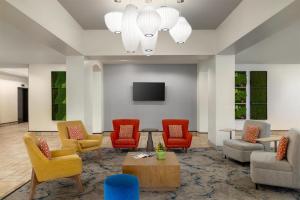 a waiting room with chairs and a tv at Hilton Garden Inn Raleigh-Durham/Research Triangle Park in Durham