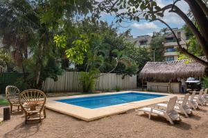 a swimming pool with chairs and a table and a building at MK Hotel Beach in Playa del Carmen