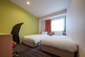 a hotel room with two beds and a window at the b ikebukuro in Tokyo +41 photos