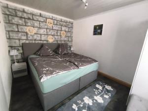 a small bedroom with a bed and a brick wall at FeWo Mephisto in Pottenstein