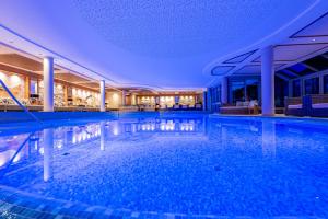 a large swimming pool in a building with a ceiling at Meiser SPA Resort in Fichtenau