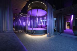 a bed in a room with purple lighting at Meiser SPA Resort in Fichtenau