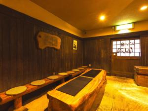 a room with a row of wooden tables in it at Hotaru no Yado Sendou in Yufu
