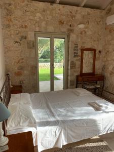 a bedroom with a large bed and a mirror at Kouvarata Villas Stavros in Vathi