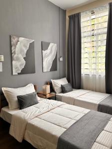 a bedroom with two beds and a window at Adwa Guesthouse in Keningau