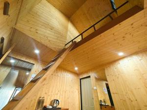 a large wooden room with stairs in the ceiling at Beyond Baari Inn in Darjeeling