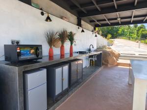 a kitchen with a tv on a counter at Spacious & Scenic View with Swimming Pool Aza Sunset Villa 2 in Langkawi Intl
